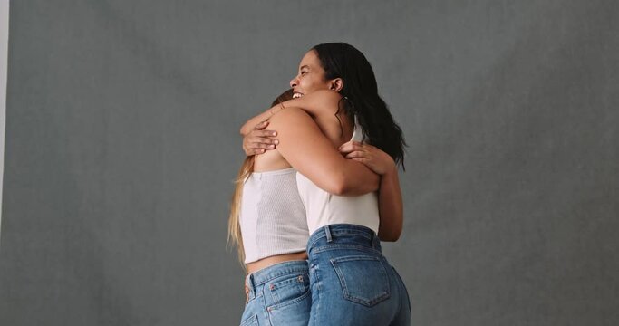 Two smiling and happy girlfriend embrace in a welcome gesture