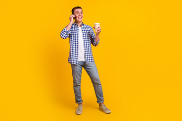 Portrait of happy man talking on phone drinking tea isolated over bright vibrant color background