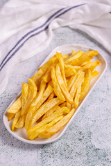 Fried potatoes. French fries on stone background. French fries served on a plate. close up