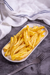 Fried potatoes. French fries on dark background. French fries served on a plate. close up