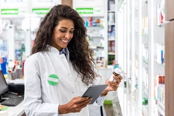 Aluminium Prints Pharmacy Female pharmacist working in pharmacy using digital tablet during inventory.