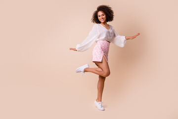 Fototapeta na wymiar Full length photo of cute shiny girl dressed white blouse dancing having fun empty space isolated beige color background