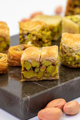 Varieties of pistachio baklava. Variety of baklava isolated on white background. Traditional Turkish cuisine delicacies. Desserts with pistachio syrup in the middle. close up