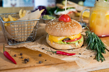 A burger with veal, lettuce leaves, tomatoes and pickles