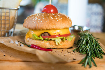 A burger with veal, lettuce leaves, tomatoes and pickles