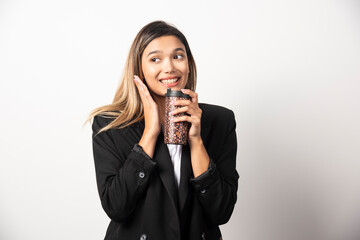 Business woman holding cup and posing on white background