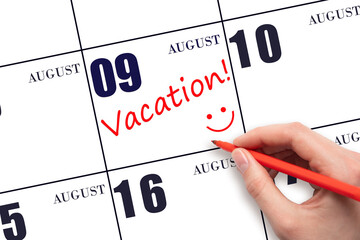A hand writing a VACATION text and drawing a smiling face on a calendar date 9 August. Vacation...