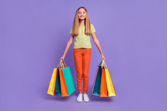 Full body photo of positive cute girl hands hold shop packages isolated on violet color background