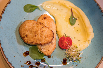 Mashed potatoes with beef patty and tomato