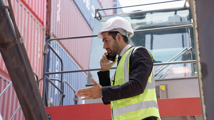 Fototapeta na wymiar Caucasian man Industrial engineer talking about the new project on mobile phone at the transport container warehouse or container terminal