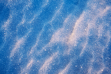 Snow frost background texture. Blue cold wavy surface in sunlight