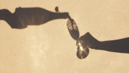 shades and silhouette concept - shadows of hands pouring wine from bottle to champagne glass - Powered by Adobe