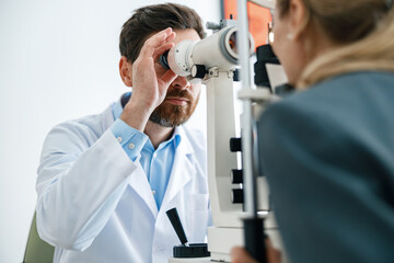 Optometrist checks the patient's intraocular pressure in optician's shop or ophthalmology clinic