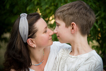 portraite of smiling happy mother with his son in summer park