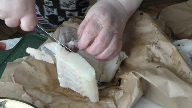 the cook cuts into pieces sea fish cod
