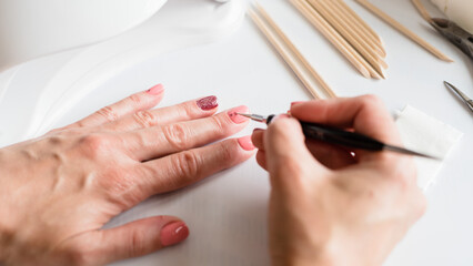 Obraz na płótnie Canvas Manicure for yourself. Strengthening natural nails with artificial gel material. Nail care. Close-up