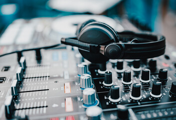 Black headphones for professional Dj on dj console mixer in concert outdoor