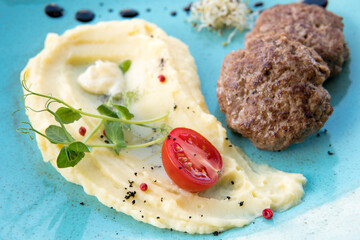 Mashed potatoes with beef patty and tomato