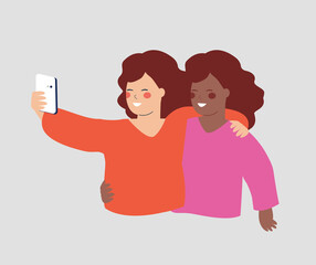 Woman embraces her best friend and talking selfie. Women hug each other and hold a smartphone for texting, listing to music or chatting online. Concept of mobile usability, friendship and technology.