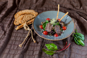 Meat salad with herbs, tomatoes and breadsticks
