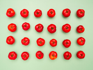 Ripe red acerola cherries isolated on a light green background