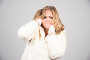 Blonde woman in winter outfit holding her hair