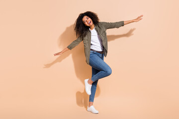 Fototapeta na wymiar Full length body size view of attractive cheerful girl flying having fun isolated over beige pastel color background