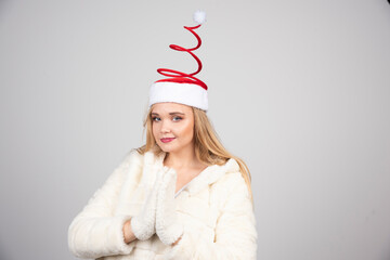 Woman in Santa hat standing on gray background