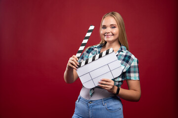Young blonde model holding a blank movie filming clapper board and having fun