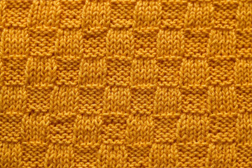 Yellow seamless knited texture close up. Knitted chess pattern. Knited background.