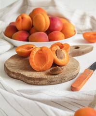 Apricot slices on a wooden cutting board. Fresh organic apricots. Apricots peeling process.