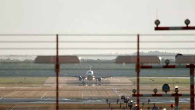 Aircraft land on with strong side wind at airport. View from the beginning of runway.
