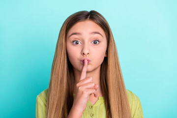 Naklejka premium Photo of little girl finger cover lips demonstrate shh gesture isolated on turquoise color background