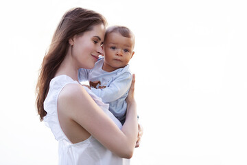Mother hugs and holds child in her arms isolated on white background. Beautiful multiracial family