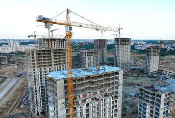 Fototapeta na wymiar Сonstruction site with tower cranes on building construction. Builder on formworks. Cranes on pouring concrete in formwork. Tower cranes on construction in built environment. Buildings renovation..