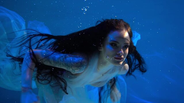 Slow Motion Beautiful woman swimming with fancy dress underwater