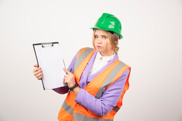 Fototapeta premium Female builder in hardhat with tablet on white background