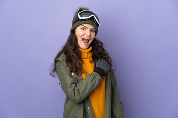 Teenager Russian girl with snowboarding glasses isolated on purple background celebrating a victory