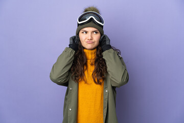 Teenager Russian girl with snowboarding glasses isolated on purple background frustrated and covering ears