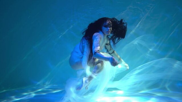 Slow Motion Young woman underwater in a beautiful dress underwater shooting