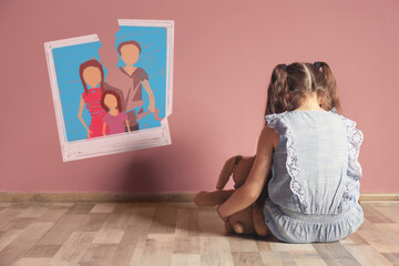 LIttle girl upset because of parents divorce at home. Illustration of torn family photo