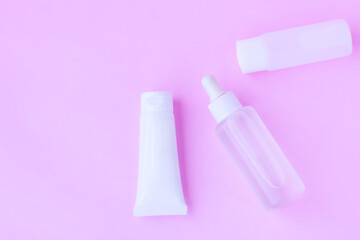 Cosmetic bottles on pink background