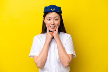 Airplane Chinese woman stewardess isolated on yellow background smiling with a happy and pleasant expression