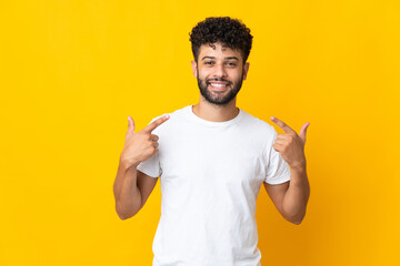 Young Moroccan man isolated on yellow background giving a thumbs up gesture