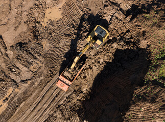 Excavator during clay mining.  mining in open pit. Aerial view of an opencast for the extraction of clay and limestone. Brick and Tile. Excavator at work in an quarry for development of clay.