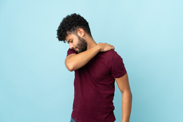 Young Moroccan man isolated on blue background suffering from pain in shoulder for having made an...