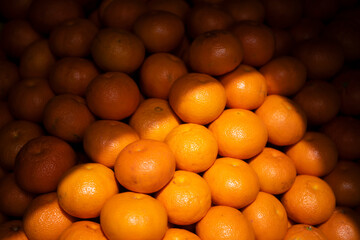 Pile of Fresh Ripe cultivated Tangerine or Clementine Citrus Fruits at street market.