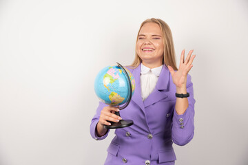 Female teacher posing with globe on white background