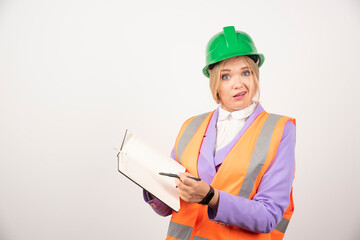 Female builder in helmet with tablet on white background