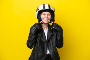 Young English woman with a motorcycle helmet isolated on yellow background giving a thumbs up gesture